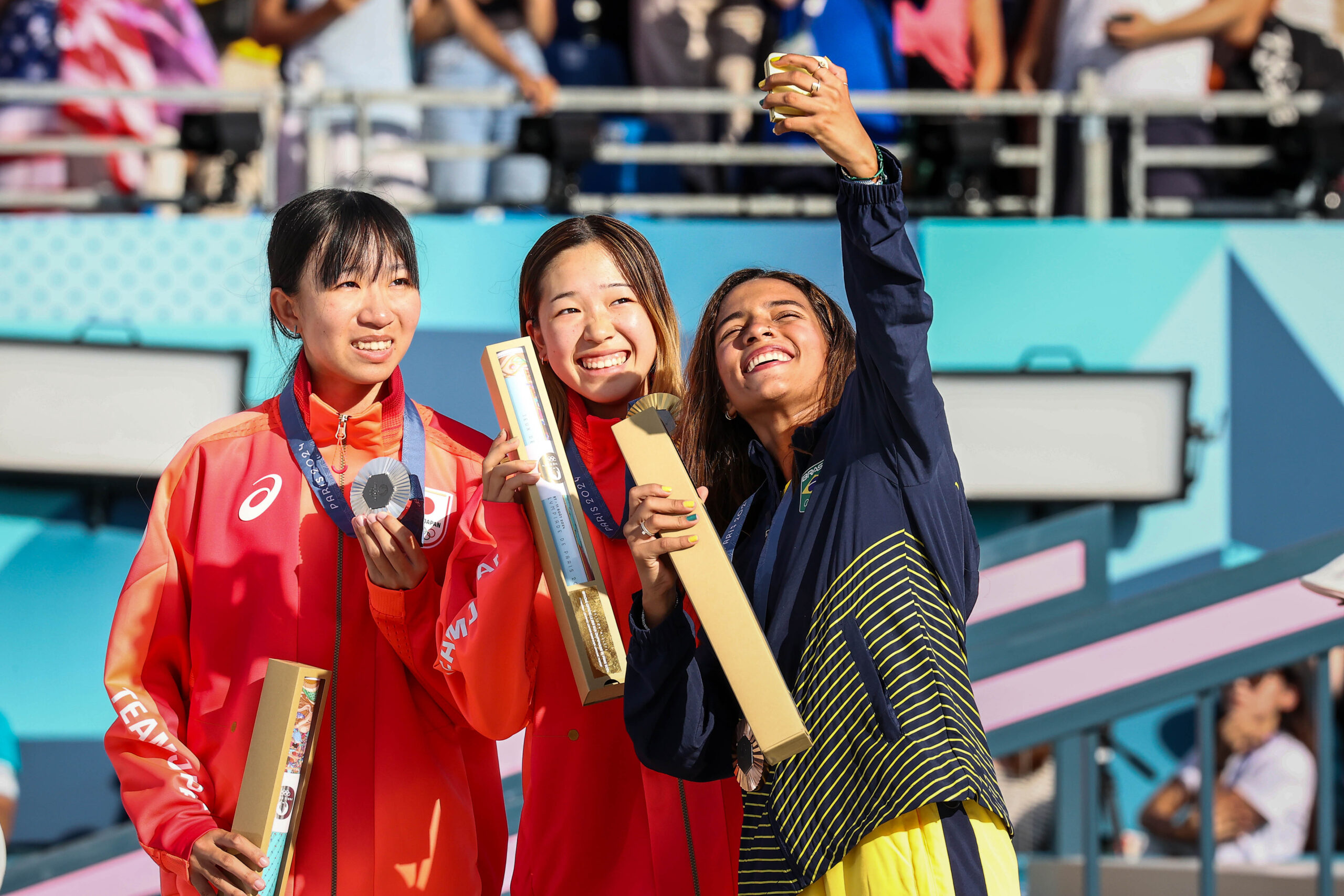 Dou femei asiatice si una americano-latina, castigatoare la JO 2024, facand selfie cu medalia
