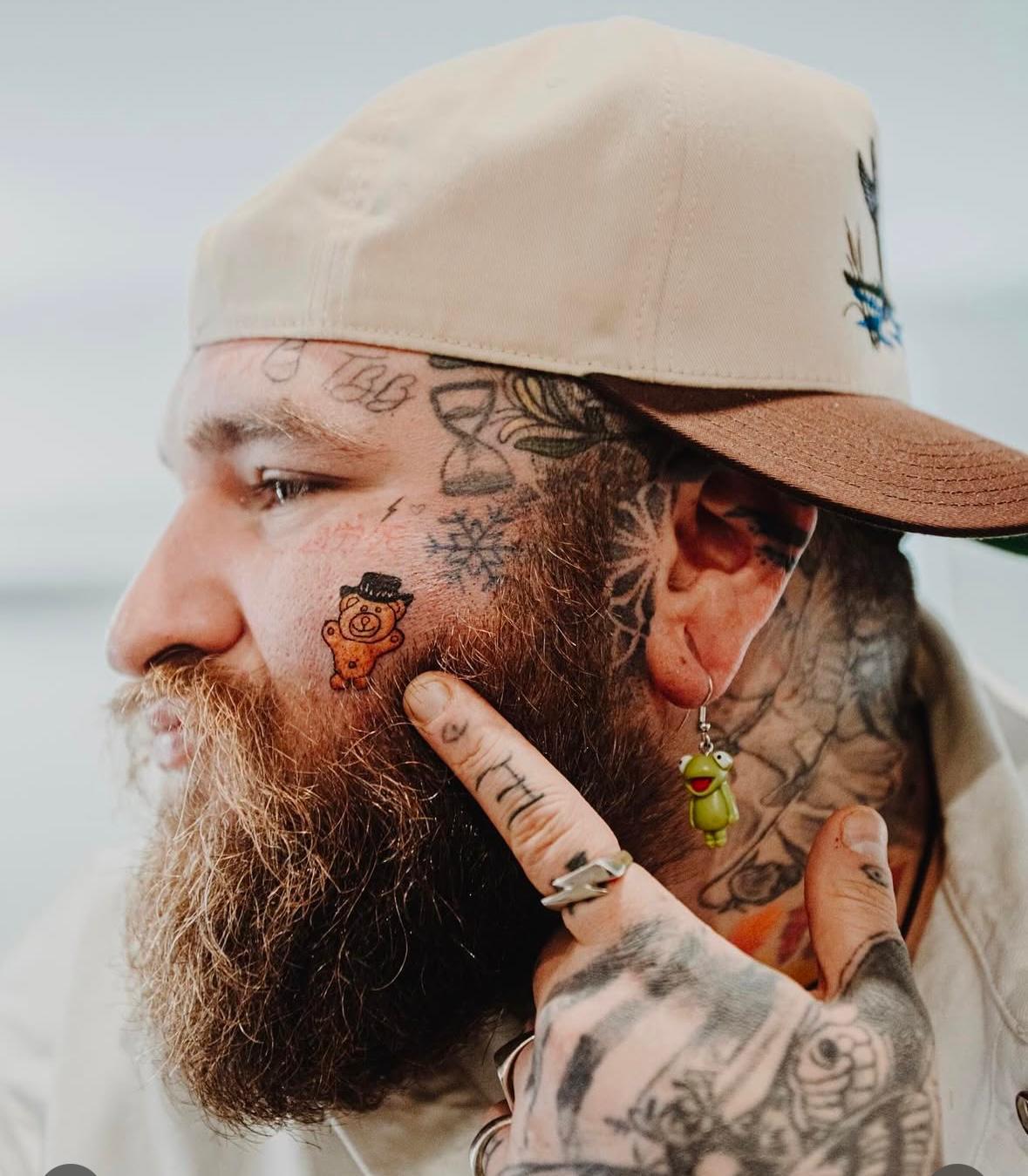 A person with tattoos on his face

Description automatically generated