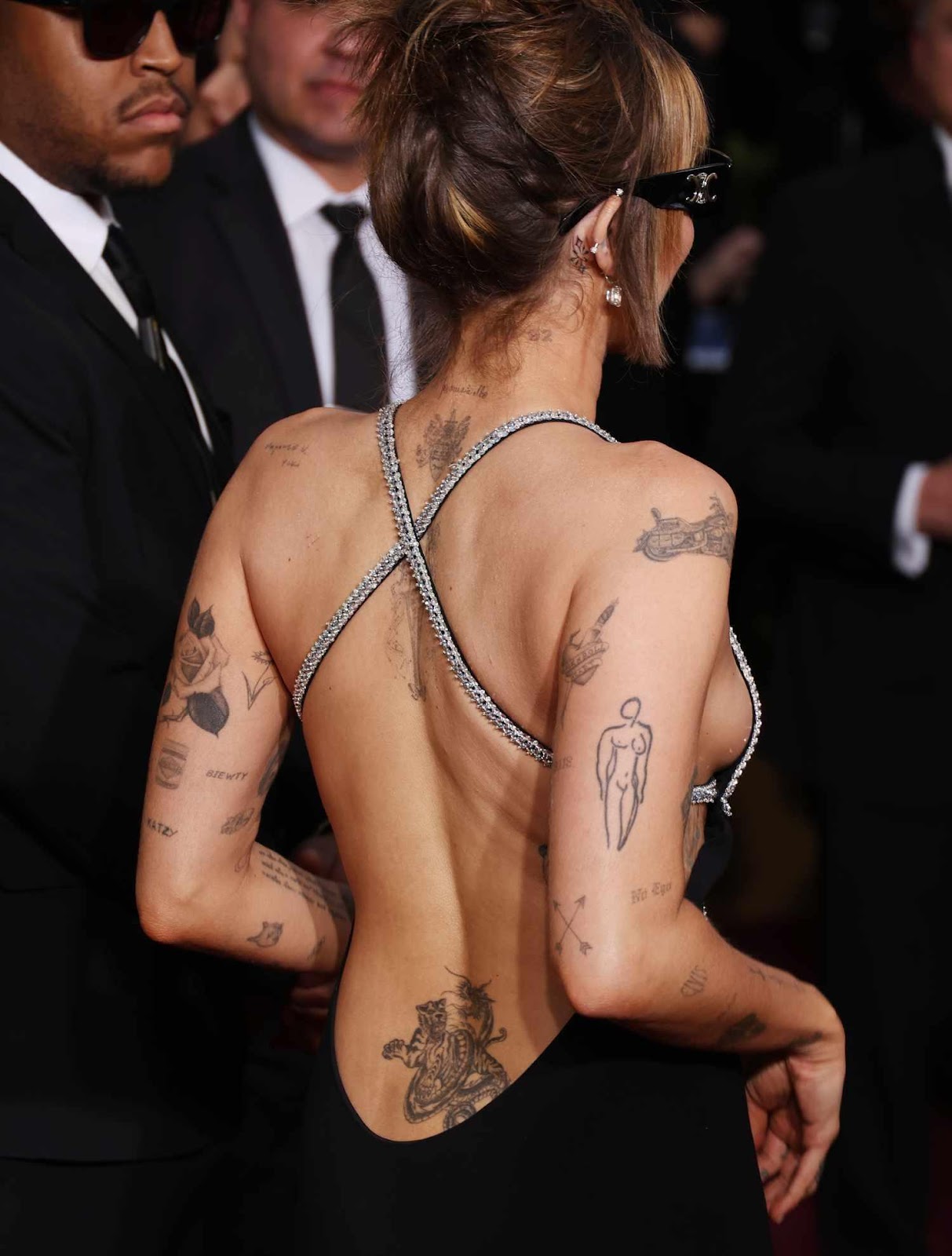 A person with tattoos on her back

Description automatically generated